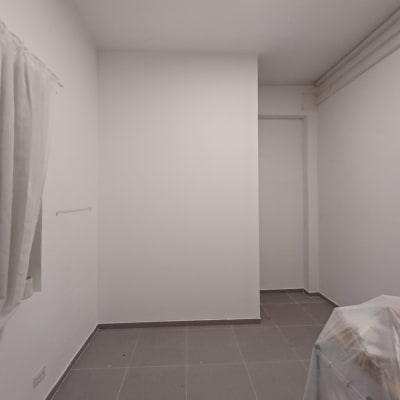 קיר גבס לבן בחדר עם רצפת אריחים אפורה