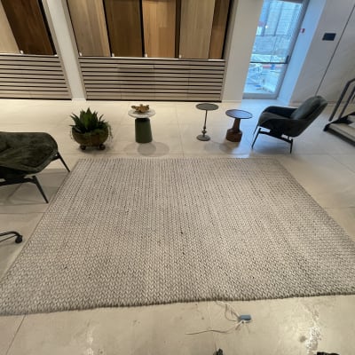 שטיח בהיר על רצפה עם כיסאות מסביב