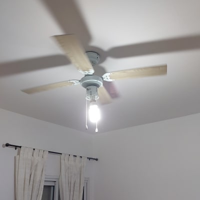 מאוורר תקרה עם מנורה מותקנים בחדר