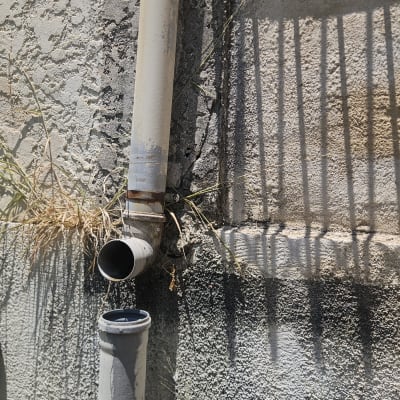 צינור מים מחובר לקיר עם סדקים