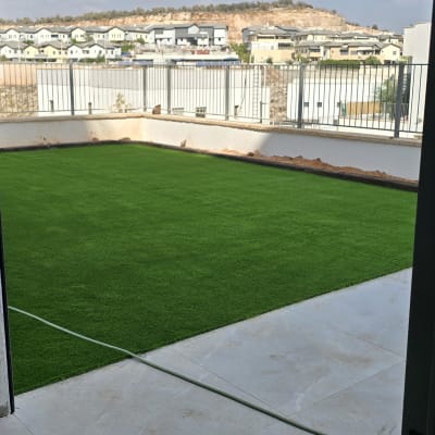 דשא סינתטי מותקן בחצר עם נוף עירוני