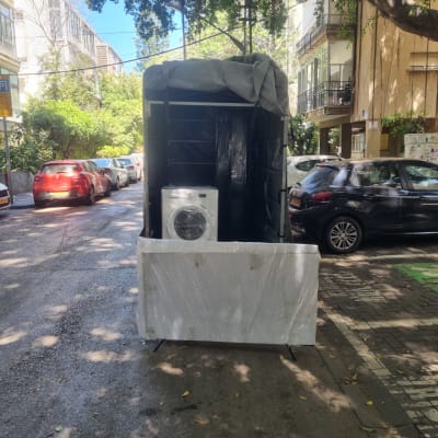 מכונת כביסה עטופה על עגלה ברחוב