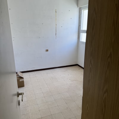 חדר ריק עם קופסה על הרצפה וקיר לבן