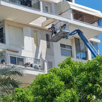 פועלים על מנוף עובדים על בניין גבוה