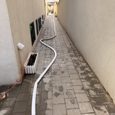 צינור לבן מונח לאורך שביל מרוצף