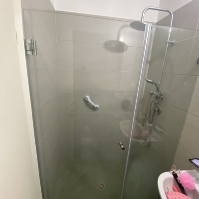 מקלחון חזית מזכוכית עם דלת ציר מותקן בחדר רחצה