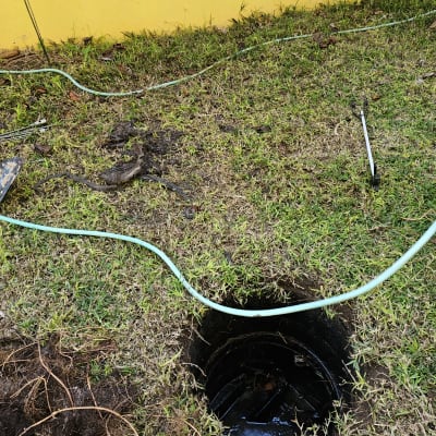 בור פתוח עם צינור ירוק על דשא