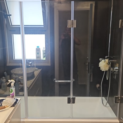 מקלחת עם דלת זכוכית, ראש מקלחת וספוג רחצה