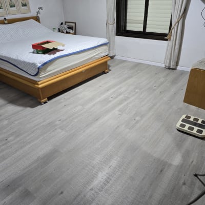 רצפת פרקט אפורה בחדר שינה עם מיטה