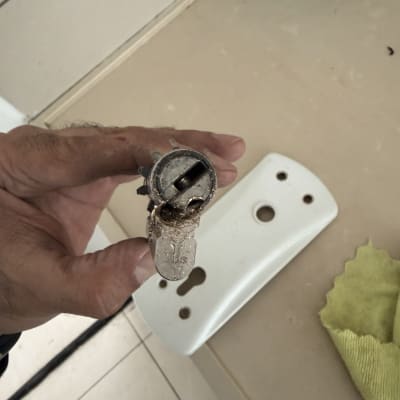 מנעול ישן מוחזק ביד על רקע שולחן