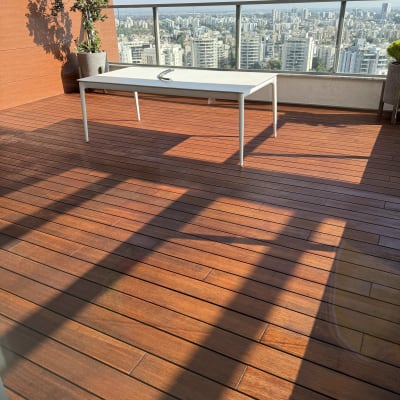 מרפסת עם רצפת עץ ושולחן לבן