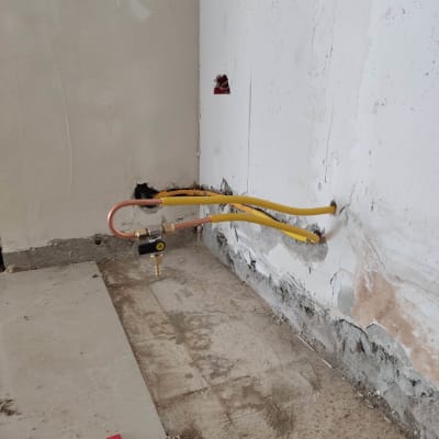 צינורות גז צהובים מחוברים לקיר עם שסתום