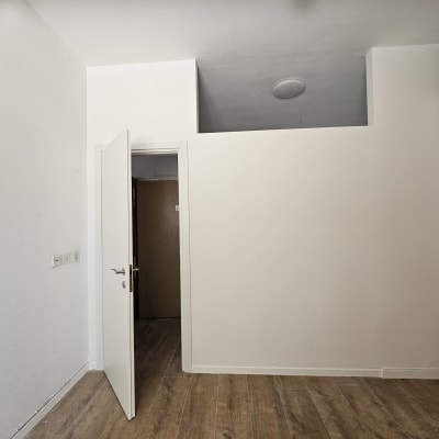 קיר גבס עם דלת פתוחה ורצפת עץ