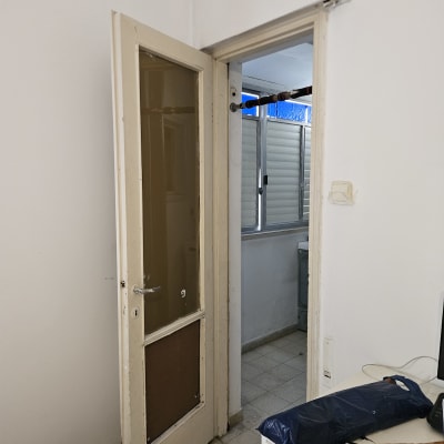 דלת פתוחה עם תריסים בחדר סמוך