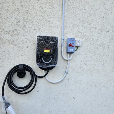 מטען לרכב חשמלי מותקן על קיר עם כבל טעינה