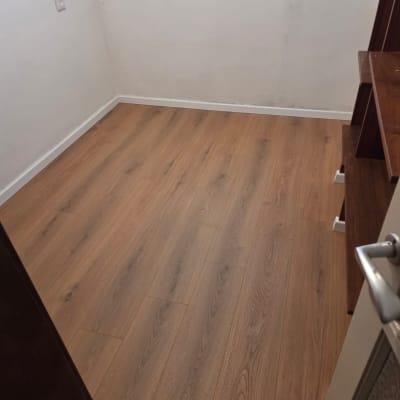 רצפת פרקט בחדר קטן עם קיר לבן