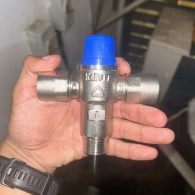 שסתום מתכת עם כובע כחול ביד אדם