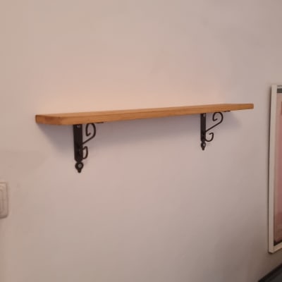 מדף עץ מותקן על קיר עם סוגרים ממתכת