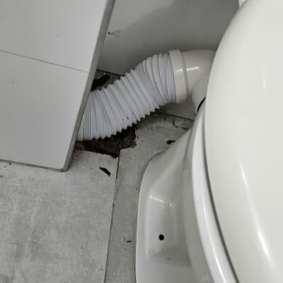 צינור גמיש מחובר לאסלה בחדר אמבטיה