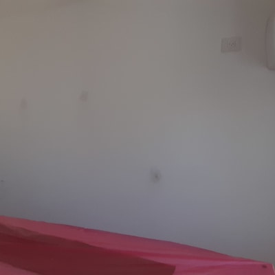 קיר לבן עם סימנים, שולחן מכוסה בניילון אדום