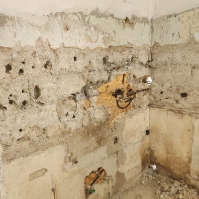 קיר בטון חשוף עם חוטי חשמל ועבודות שיפוץ