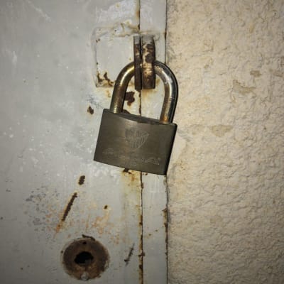 מנעול תלוי על דלת מתכת חלודה