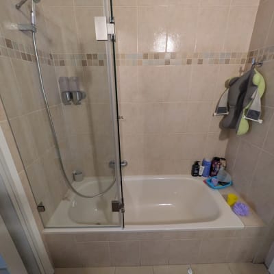 אמבטיה עם מקלחון, מוצרי טיפוח ומתקן תלייה