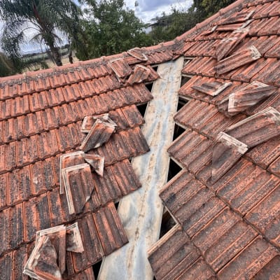 תמונה של גג רעפים עם רעפים שבורים ותיקון