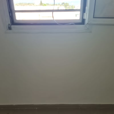 קיר צבוע בלבן עם חלון פתוח