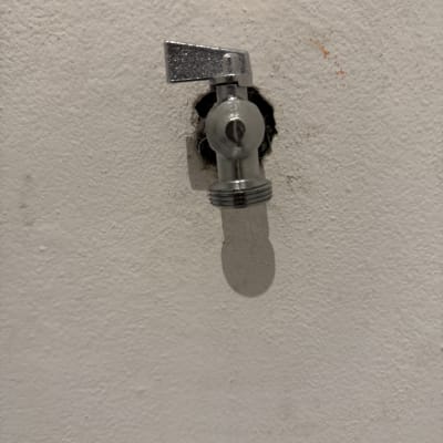 ברז מים מותקן על קיר לבן