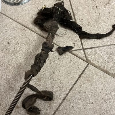 כלי אינסטלציה עם לכלוך ושערות על רצפה