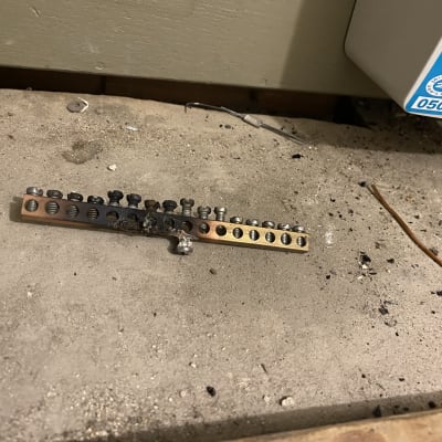 פס חיבורים חשמלי עם ברגים על רצפה מאובקת