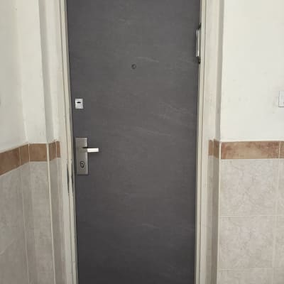 דלת אפורה עם ידית כסופה במסגרת לבנה