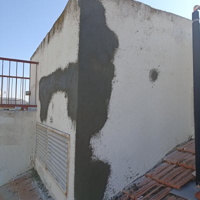 תיקון קיר עם חומר איטום אפור על גג רעפים