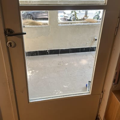 דלת זכוכית עם נוף חיצוני של עצים ומכוניות