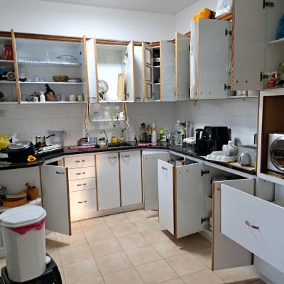 מטבח עם ארונות פתוחים, כלים ומכשירי חשמל על השיש