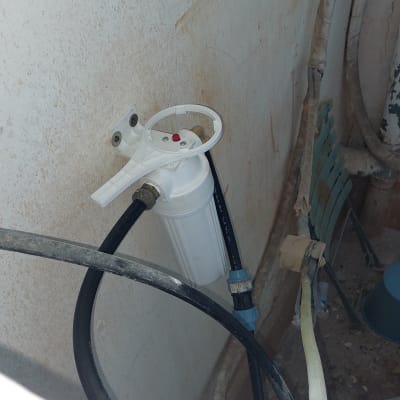 מסנן מים עם צינורות מחוברים לקיר
