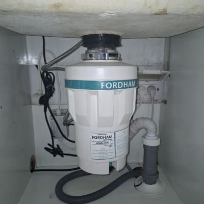 מכשיר טוחן אשפה מותקן מתחת לכיור במטבח