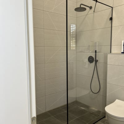 מקלחת עם ראש גשם ודלת זכוכית שקופה