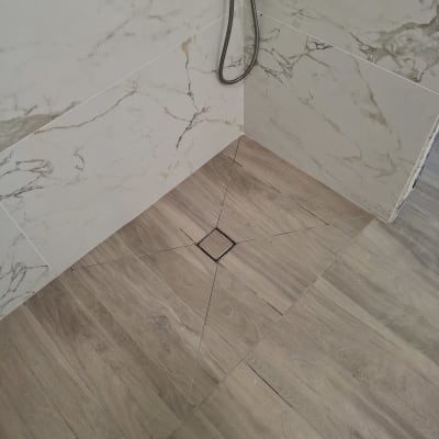 ריצוף חדש בחדר אמבטיה עם קירות שיש