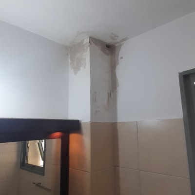 קיר עם קילופי צבע ודלי צבע על השולחן