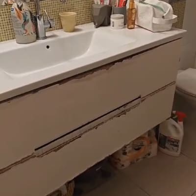 ארון אמבטיה עם מגירות פגומות מתחת לכיור