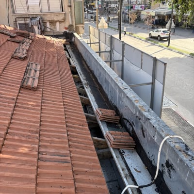 תמונה של גג רעפים עם תיקונים ועבודות תחזוקה