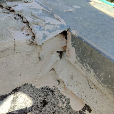 סדק בקיר עם צינור ירוק מעליו