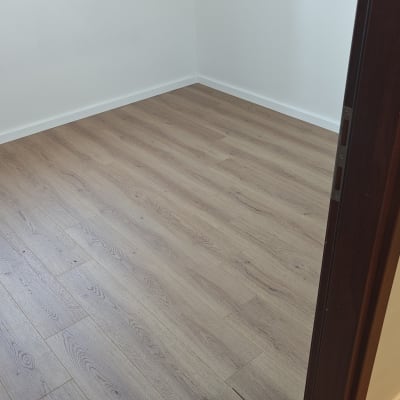 רצפת פרקט בחדר ריק עם דלת פתוחה