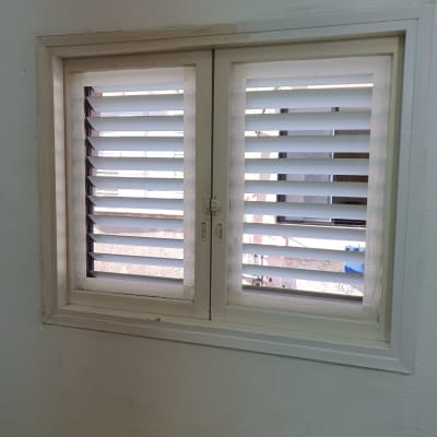חלון עם תריסים נקיים ומסגרת לבנה