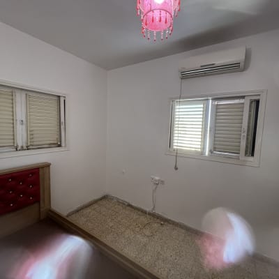 חדר ריק עם מנורה ורודה ותאורה טבעית