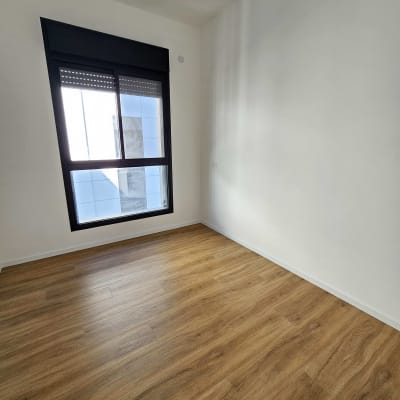 רצפת פרקט עץ בחדר ריק עם חלון גדול