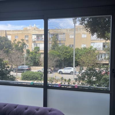 חלון אלומיניום עם מסגרת כהה ונוף חיצוני