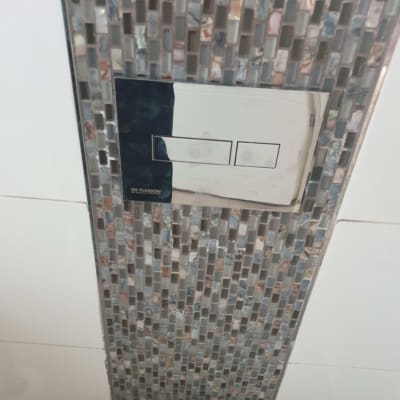 לחצן הדחה כפול על קיר אריחים צבעוניים